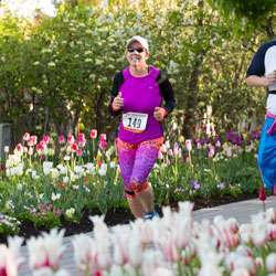 Woman running on path lined with tulips 