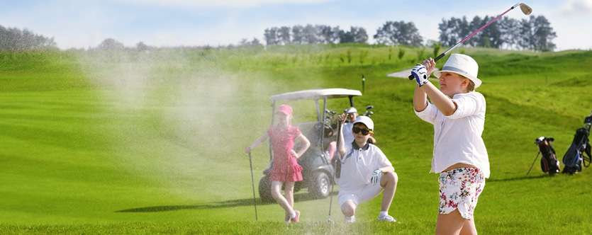 3 kids on golf course with one swinging