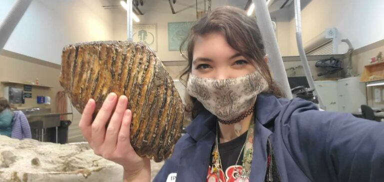 Young woman holds up a specimen at A Day in the Life of an Explorer.