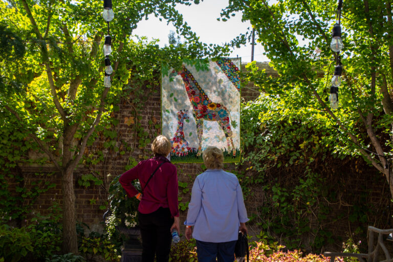 Guests observe a quilt during the Garden of Quilts exhibition.