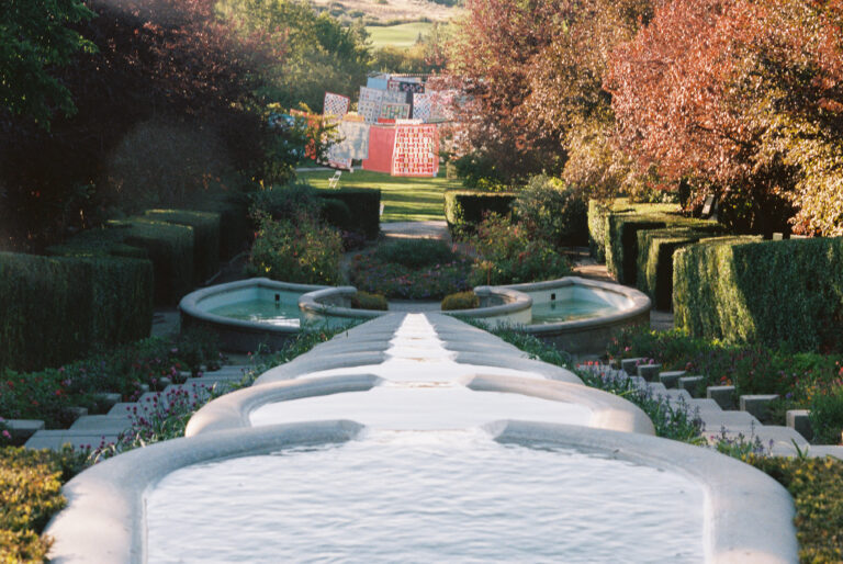 Looking out from the top of the water feature in the Italian Garden, quilts can be seen displayed in the grass.