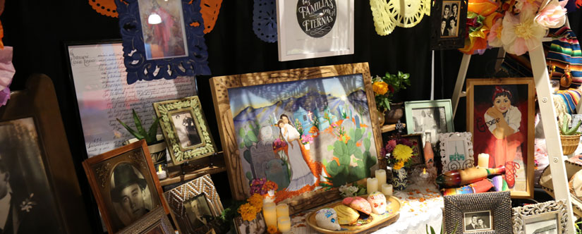 An ofrenda - a table with many photo frames of ancestors, artwork, displayed food and more. 