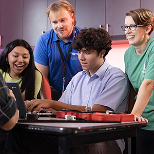 two adults helping teenage students learn