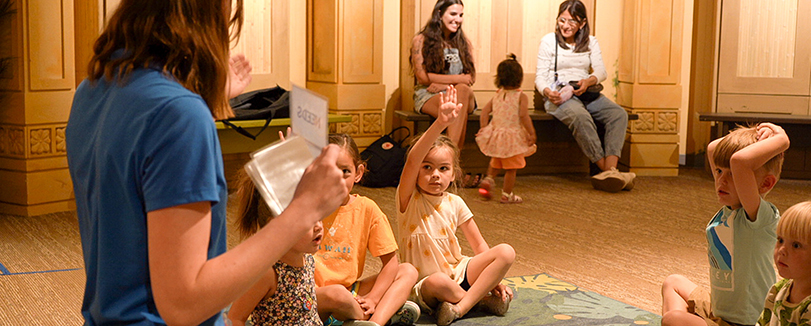 volunteer reading book to children at thanksgiving point