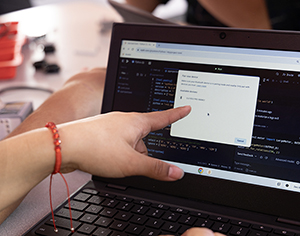 finger pointing at computer coding screen