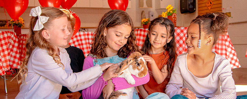 kids petting bunny with balloon in background