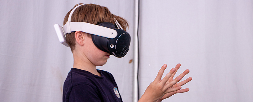 boy with vr headset on and hands out