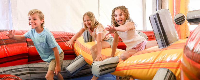 girl in obstacle course sliding down slide