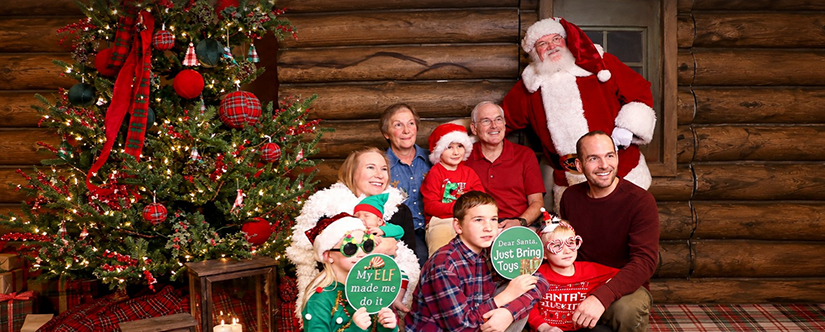 santa posing with big family in front of tree